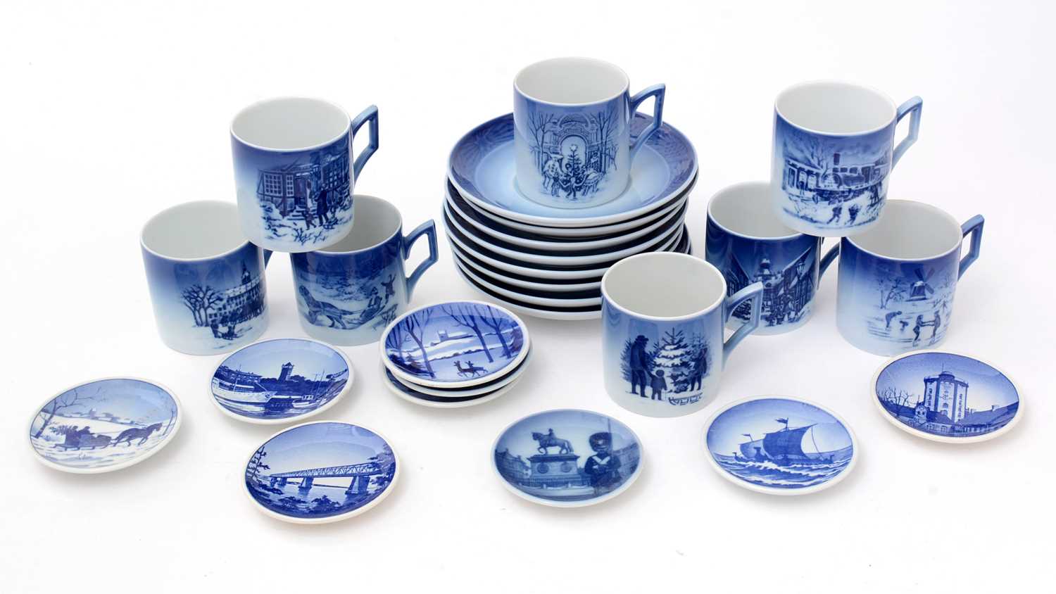 A collection of Royal Copenhagen commemorative Christmas coffee cups and saucers and dishes.