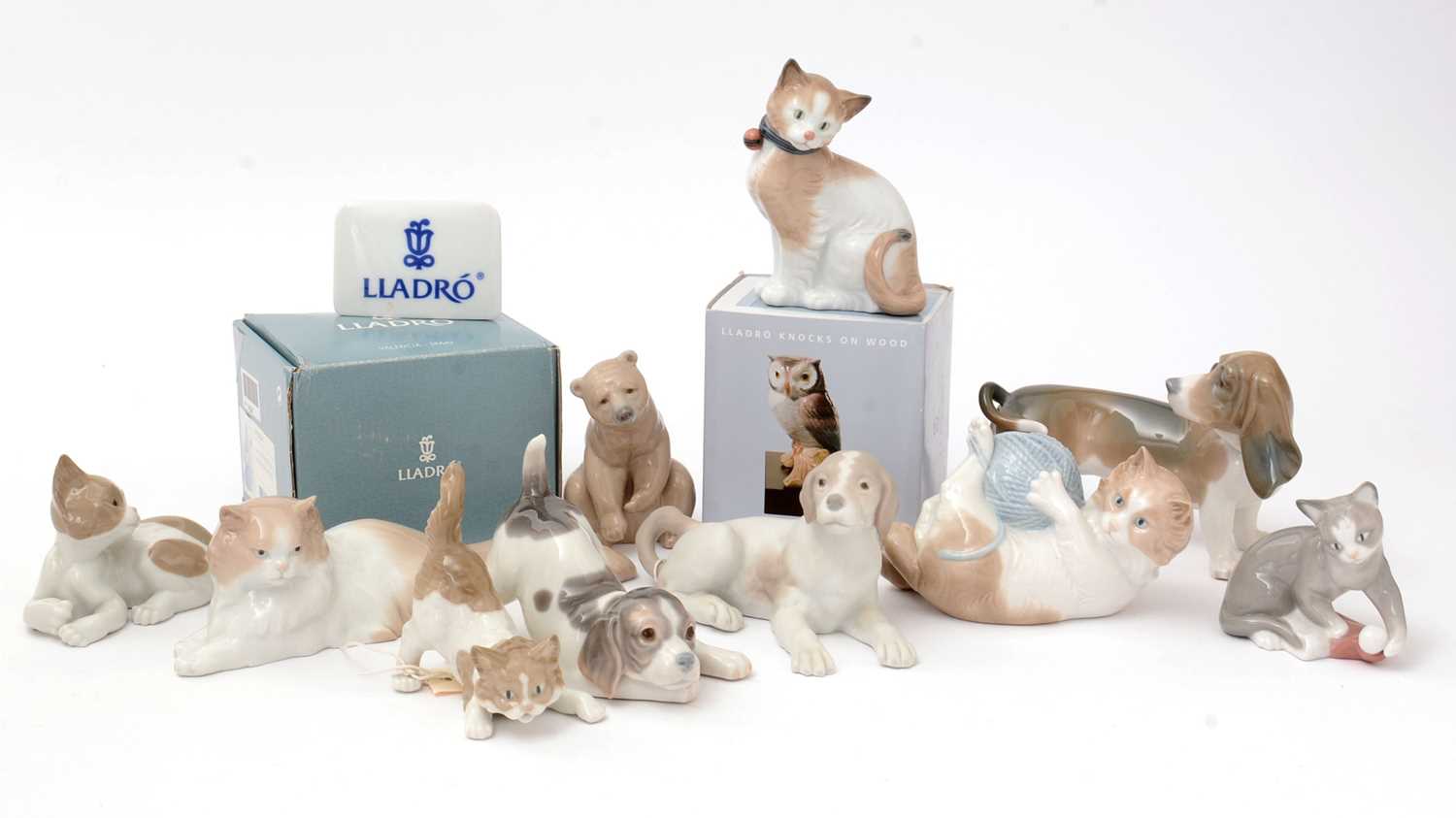 Four Lladro figures; five Nao figures; and a Lladro display sign.
