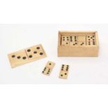 A box of carved and stained bone dominoes,