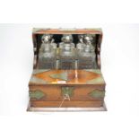 A 20th Century oak three bottle tantalus drinks cabinet