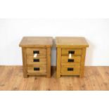 A pair of contemporary oak furniture land style bedside cabinets