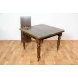 A late 19th Century extending dining table with extra leaf