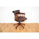 A reproduction mahogany and oxblood leatherette captain's chair