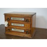 An early 20th Century table top three drawer oak needle/haberdashery cabinet by Morris & Yeomans.