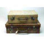 A vintage brown leather suitcase and another