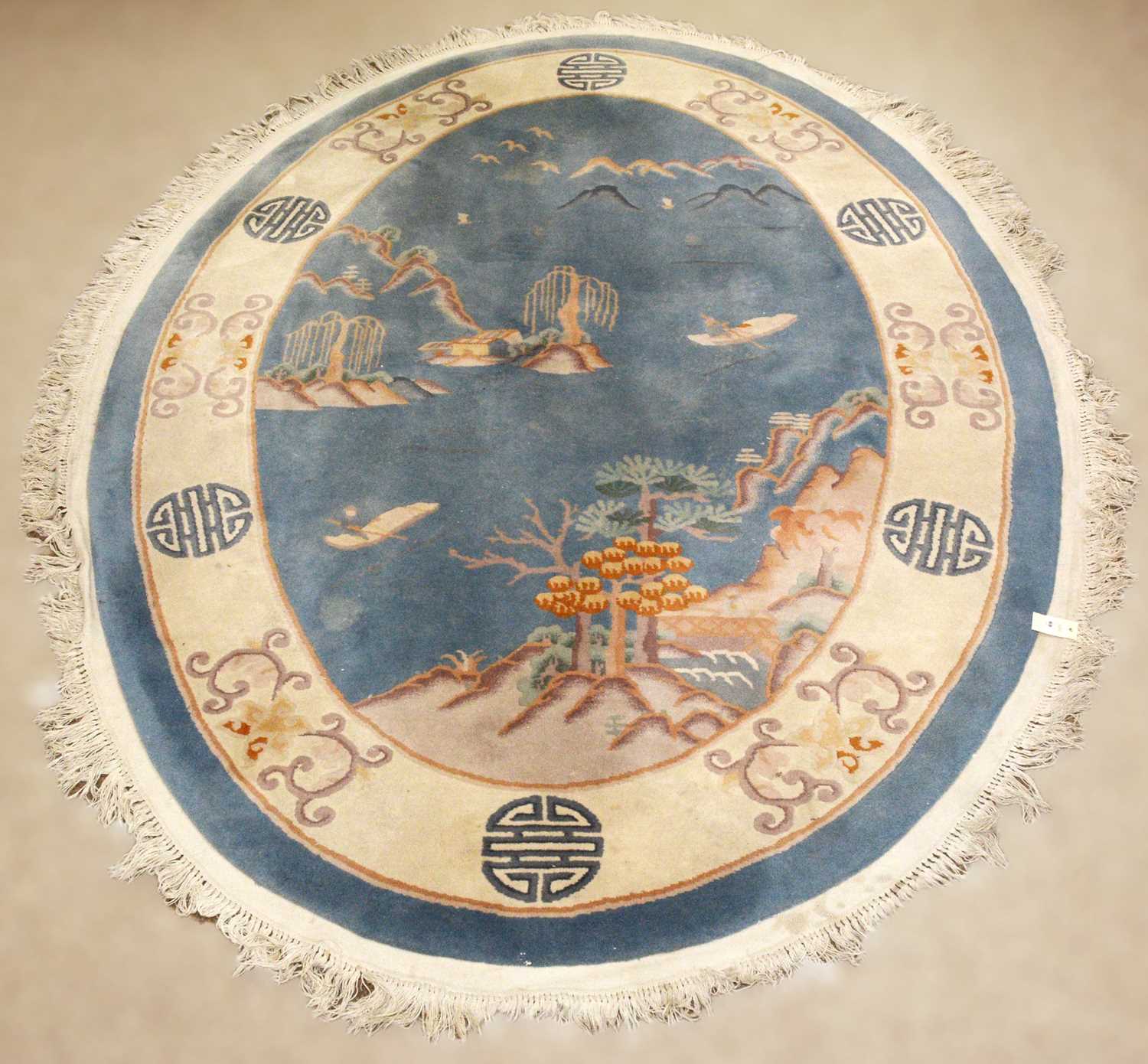 A 20th Century Chinese Oriental rug of oval form