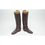 A pair of vintage brown leather riding boots.