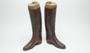 A pair of vintage brown leather riding boots.