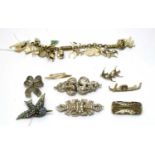 A charm bracelet; and a selection of silver and costume brooches