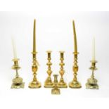 A collection of brass candlesticks and others