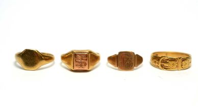 A gold buckle ring; two gold signet rings; and another