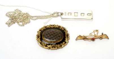 A Victorian mourning brooch, an Edwardian bar brooch, and a silver ingot pendant