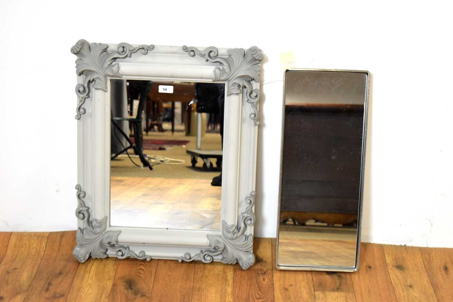 A contemporary wall mirror painted in a grey colourway with another