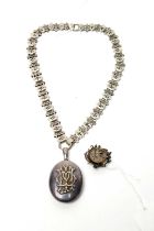 A Victorian silver locket pendant on chain; and a brooch