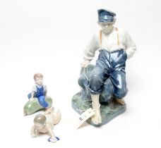 A Royal Copenhagen decorative ceramic figure; and two others