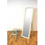A large contemporary archtop dressing mirror painted in a white colourway with a stool