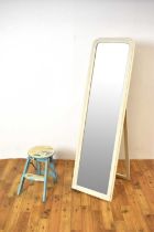 A large contemporary archtop dressing mirror painted in a white colourway with a stool