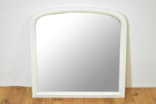 A contemporary arched overmantel mirror painted in a white colourway