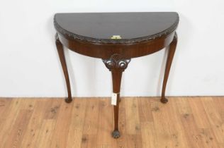 A Georgian style carved mahogany demi lune card table.