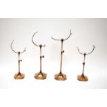 A collection of early 20th Century adjustable copper plated brass shoe stands