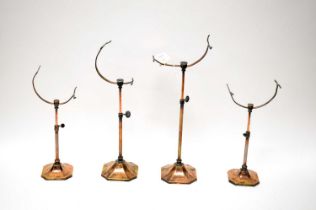 A collection of early 20th Century adjustable copper plated brass shoe stands