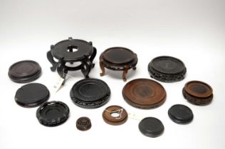 A collection of Chinese carved and ebonised wood circular stands
