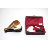 A cased meerschaum pipe; and another