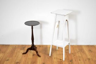 A vintage plant stand painted in a white colourway with a wine table