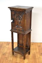 A Gothic Revival carved oak cabinet on stand