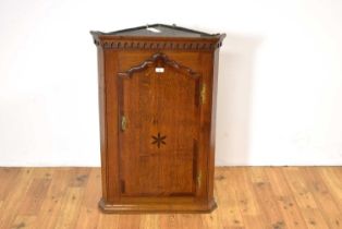 A George III inlaid oak and mahogany banded corner cabinet