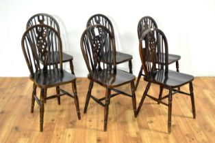 Four modern beech wheelback dining chairs and two similar smaller chairs