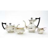 An Edwardian three piece silver tea set and matching coffee pot