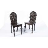 A pair of 19th Century carved oak hall chairs