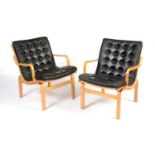Nielaus Mobler of Denmark: a pair of mid-Century teak and black leather button back lounge chairs,