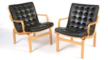 Nielaus Mobler of Denmark: a pair of mid-Century teak and black leather button back lounge chairs,