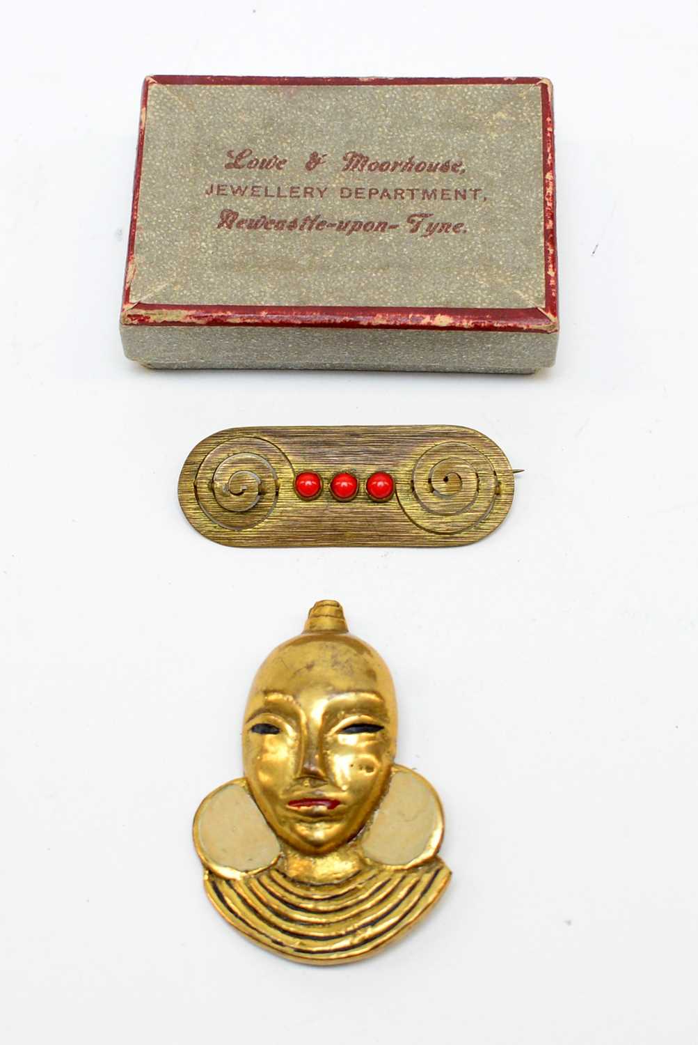 A 1920s brooch modelled as the head of a African lady, and a tribal bar brooch