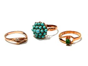 An emerald ring, a turquoise ring and another