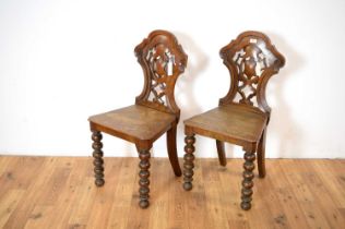 A pair of Victorian oak hall chairs