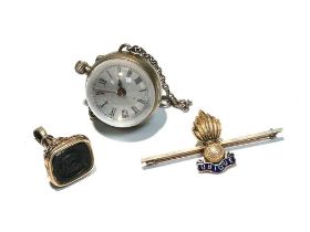 A fob watch; a fob seal; and an enamelled brooch