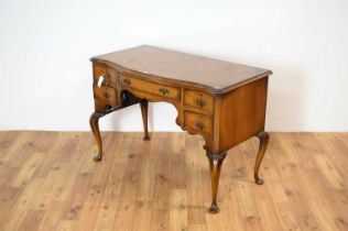 An early 20th Century walnut and burr walnut serpentine kneehole desk