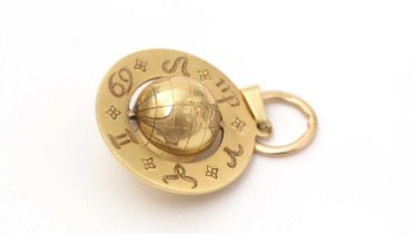 An astrological yellow gold globe pendant