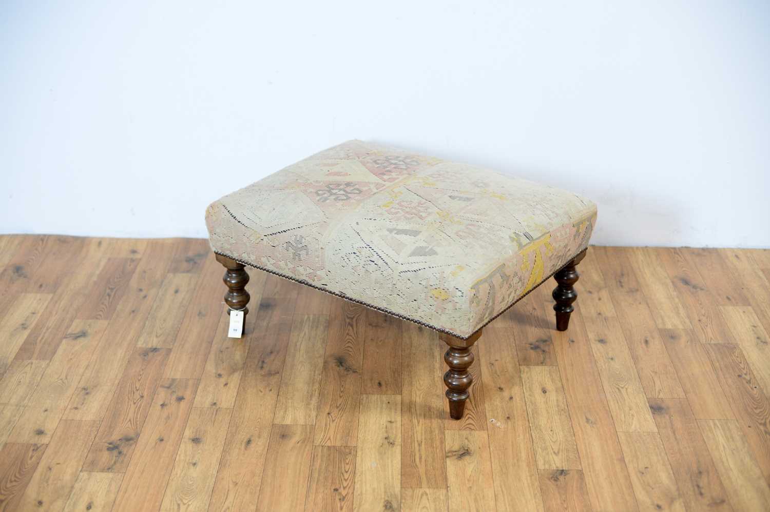 A large cushioned footstool of rectangular form