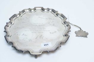 A silver presentation salver; and a decanter label