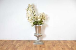A large reproduction orchid set within a silvered urn