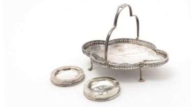 A George V silver swing handled basket; and two silver ashtrays