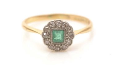 An emerald and diamond cluster ring