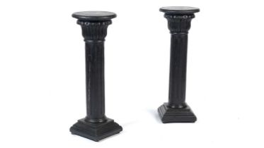 A pair of decorative ebonised classical column style pedestals