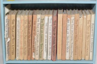 A collection of Beatrix Potter books on a small bookshelf.
