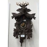 A West German Black Forest style small cuckoo clock (A/F) carved with animals and surmounted by