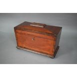 A Regency mahogany sarcophagus form tea caddy, the interior with twin lidded boxes flanking a centre